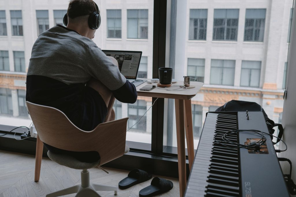 Minimalist home office setup with a laptop and piano, ideal for remote work and digital nomads.